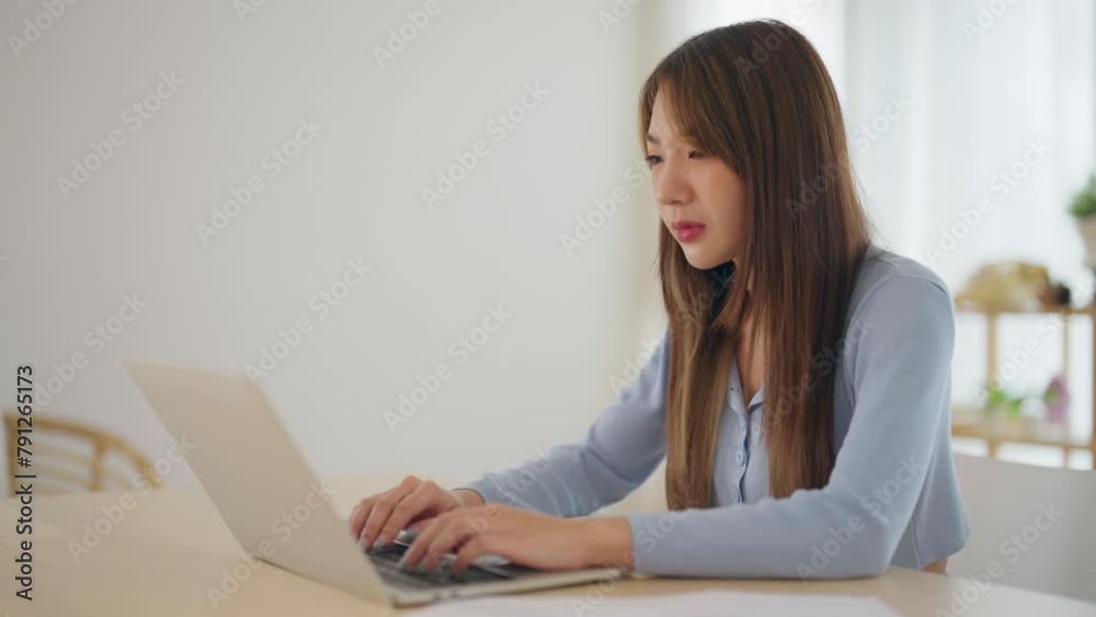 Young Asian woman working from home using computer laptop. Woman is sick and coughing health and insurance concept Young Asian woman working from home using computer laptop. Woman is sick and coughing health and insurance concept