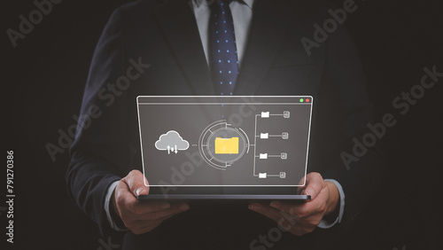 A man is holding a tablet with a cloud icon, folder and document on the screen. Concept of cloud data storage and modern online document management system.