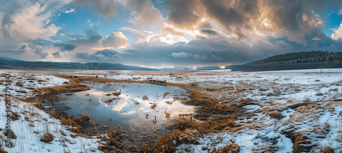Wide-angle landscape photo overlooking a mountain lake with a backdrop of mountains