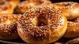 Freshly prepared vegan bagels, close-up, with a glossy top sprinkled with sesame seeds, on a linen cloth. 