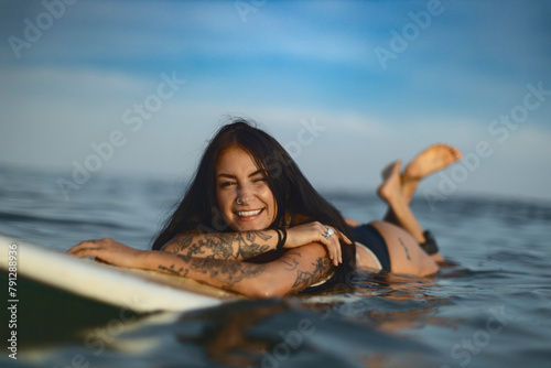 Candid lifestyle portrait of a woman on a surfboard