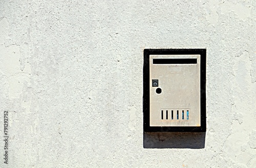 Modern metal mailbox on a white wall © Ruslan