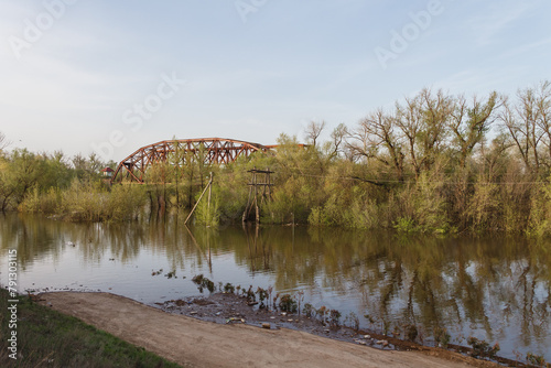Cast iron railway bridge over the Chagan River in the city of Uralsk. Rise of the river. The river overflowed its banks.