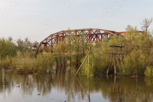 Cast iron railway bridge over the Chagan River in the city of Uralsk. Rise of the river. The river overflowed its banks.