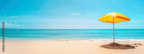 A yellow beach umbrella offers shade on a sunny beach day, perfect for wallpaper background or banner backdrop, empty space or copyspace editable