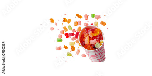 flat lay of colorful candy spilling out from paper cup on pink background