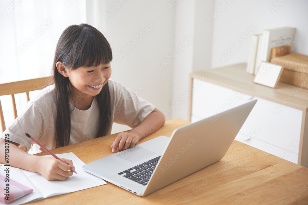 ダイニングでオンライン学習をする女の子 ダイニングでオンライン学習をする女の子