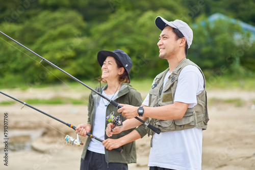 浜辺で釣りをする男女 photo