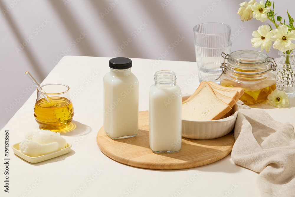 Healthy breakfast with bottles of milk and a bowl of sandwich slices featured on a chopping board. A dish of butter, a jar filled with honey and a jar of ginger jam displayed Healthy breakfast with bottles of milk and a bowl of sandwich slices featured on a chopping board. A dish of butter, a jar filled with honey and a jar of ginger jam displayed