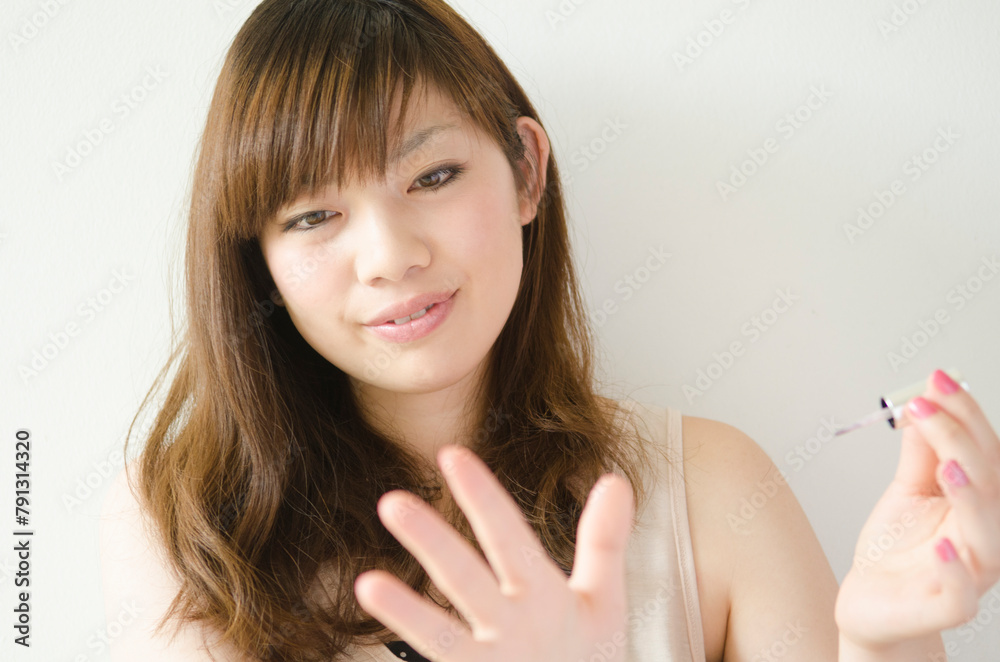 マニキュアを塗った手を見ている女性 マニキュアを塗った手を見ている女性