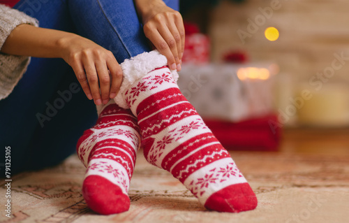 Christmas, socks and feet of person in home with cozy, comfortable and warmth for traditional festival. Winter, house and legs relax on floor in living room for holiday, vacation and festive event