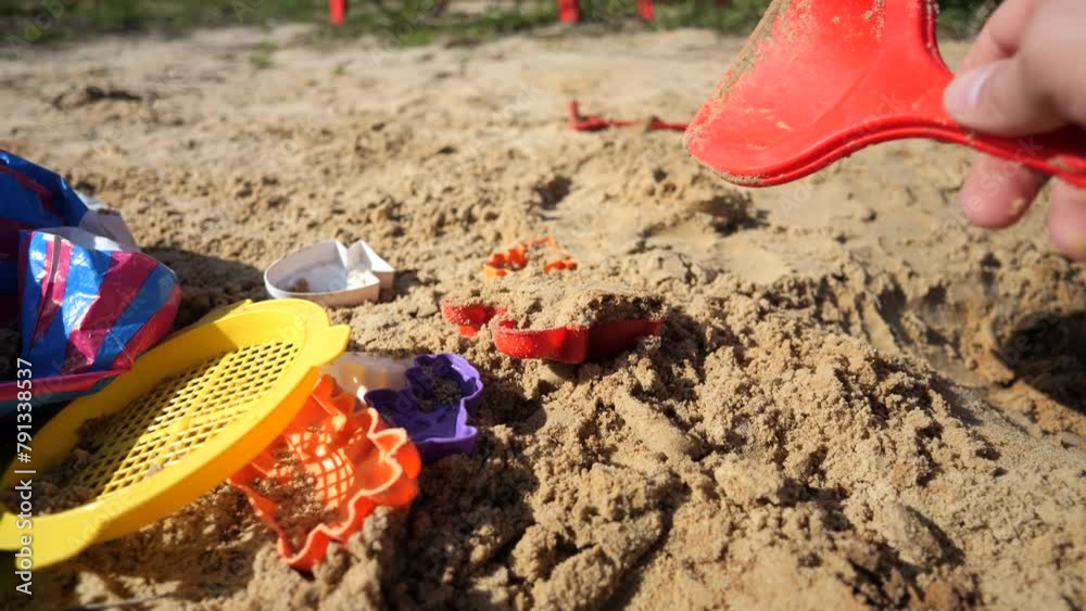Little boy plays in the sandbox with his mother, a dump truck and a tractor Little boy plays in the sandbox with his mother, a dump truck and a tractor