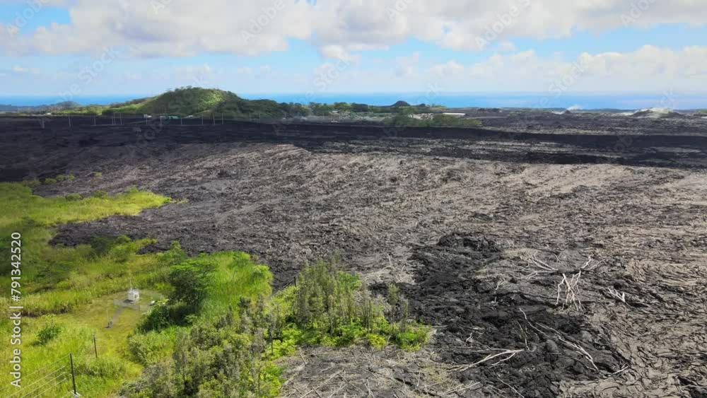 Drone pans, revealing expansive lava fields on Big Island, Hawaii, juxtaposed with unaffected areas from Leilani Estates eruption