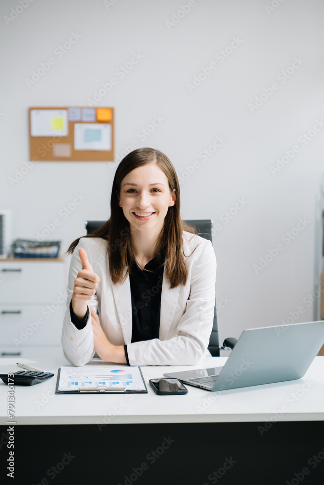 Young woman using laptop and tablet while sitting at her working place. Concentrated at work..