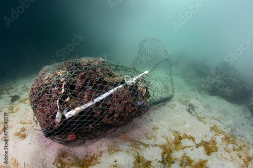 Clean up the ocean by collecting waste. Abandoned debris fishing net or ghost net and plastic garbages in the sea. Save the ocean and underwater world from trash pollution. Environmental conservation