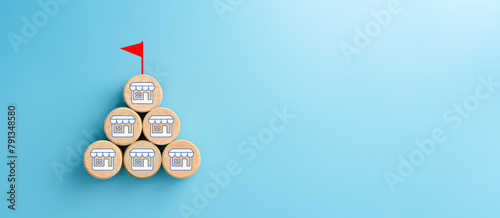 Wooden cubes with franchise icons and flag target on blue background. Franchise business concept. copy space