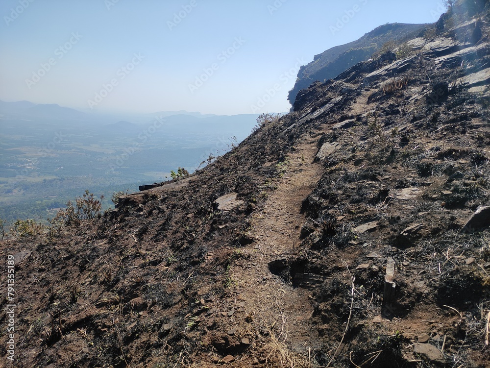 A rocky mountain trail with a clear blue sky in the background. A rocky mountain trail with a clear blue sky in the background.