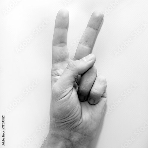 Letter V in American Sign Language (ASL) for deaf people, black and white photo of a hand