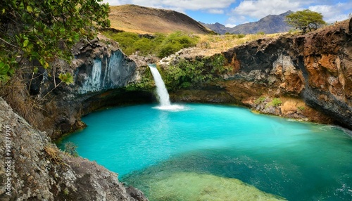 A blue water lagoon and beautiful waterfall in the mountains