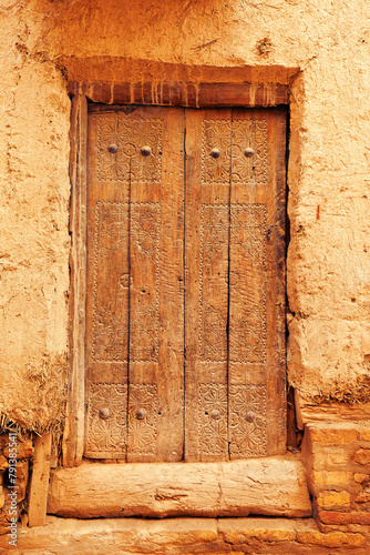 Old wooden door with traditional ornamental carving. Khiva, Uzbekistan