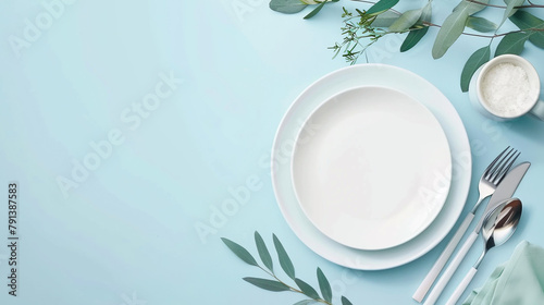 Elegant table setting with empty plate, cutlery and eucalyptus leaves on blue background. Flat lay, top view. AI.