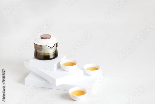 Minimalist aesthetic tea set with crystal teapot and white bowl on the podium