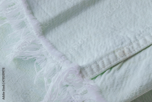 Close up of light mint jeans with white fringes , cotton fabric texture