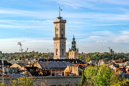 Lviv, Ukraine - November 2, 2023: Top view of the city panorama and the chapel of the Lviv Town Hall on an autumn morning. Close-up of city roofs against the backdrop of bare tree branches photo