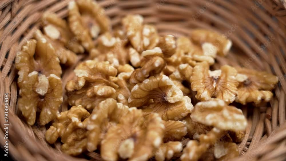 Falling nutritious raw shelled walnuts into a rattan kitchen bowl in slow motion. Healthy Ingredients Falling nutritious raw shelled walnuts into a rattan kitchen bowl in slow motion. Healthy Ingredients