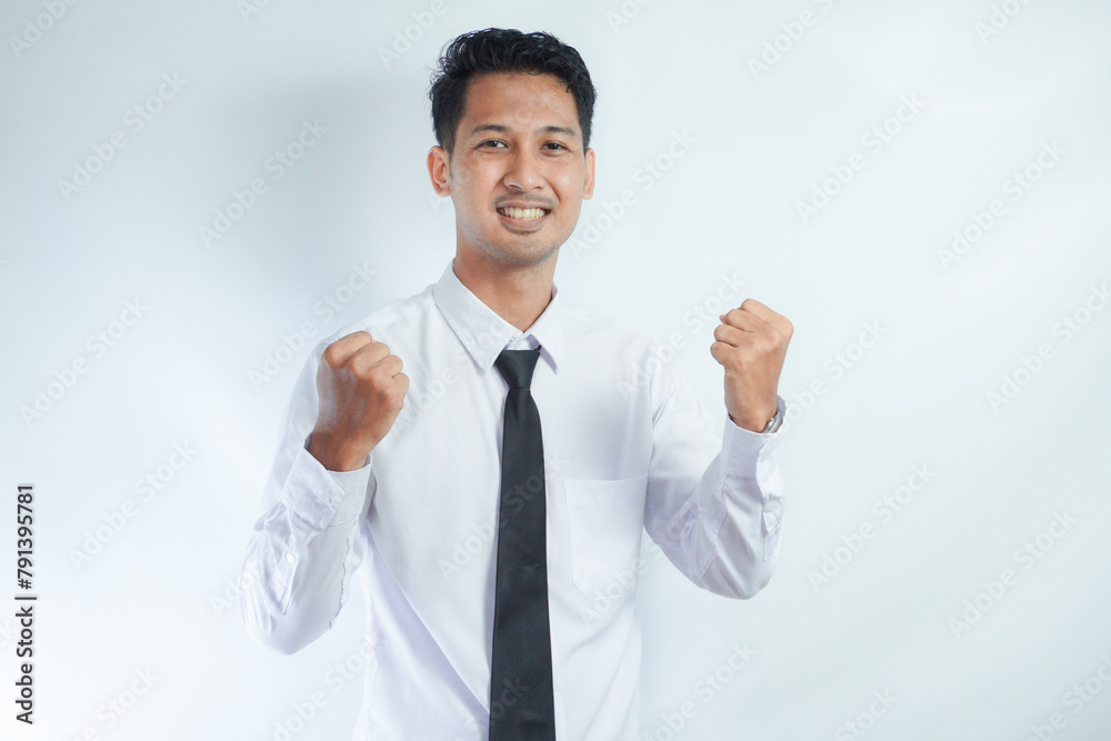 Young Asian business man showing happy excited expression with clenched fist Young Asian business man showing happy excited expression with clenched fist