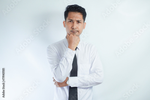 Young Asian man wearing white shirt showing thinking gesture © AriaSandi