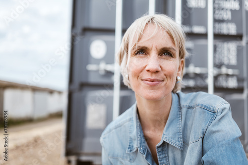 Confident Mid-Adult Blonde Woman in Urban Setting, Looking Up with Positivity
