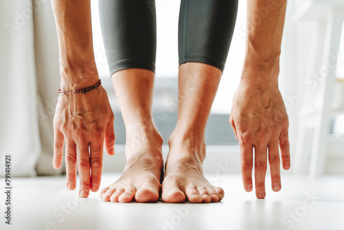 Woman practicing yoga with bare feet at home photo