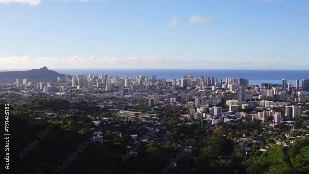 drone shot panning left across the city of Honolulu Hawaii with the Pacific Ocean in the background and blue sky from a mountain viewpoint on Oahu drone shot panning left across the city of Honolulu Hawaii with the Pacific Ocean in the background and blue sky from a mountain viewpoint on Oahu