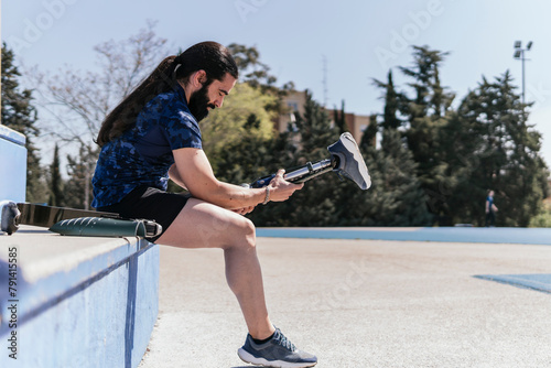 Amputed athlete wearing artificial leg at field on sunny day photo