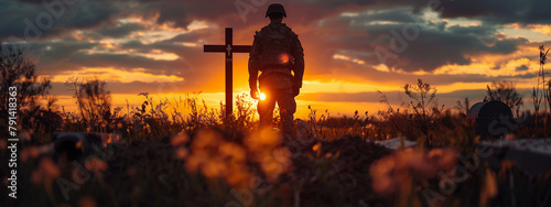 Sad military soldier army respect remembrance standing at memorial cemetery grave victim loss hero dead death die fallen in war battle silhouette sunset background photo