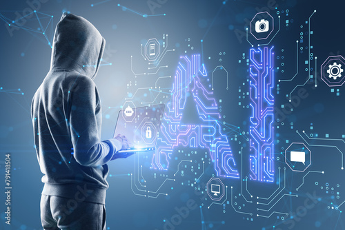 Side view of hacker in hoodie using laptop with glowing blue AI hologram on blurry background. Artificial intelligence, technology and innovation concept.