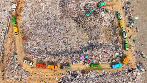 From above, a sprawling landfill sprawls like a polluted kingdom, its trash heaps forming jagged peaks. Dusty roads wind between plastic shrouds, while trucks labor to deposit their loads.

