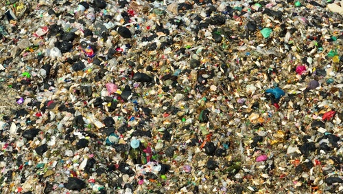 A cluttered terrain of waste, including various plastics and discarded items, a testament to the pressing issue of trash accumulation. Garbage background. Aerial view.  © Punyawee
