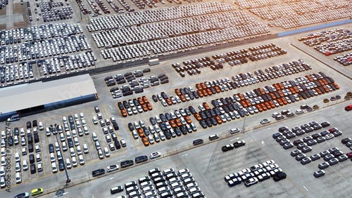 Fototapeta Naklejka Na Ścianę i Meble -  Behold the panoramic vista of a sprawling parking lot, a testament to automotive technology's prowess. Rows of cars stand aligned like soldiers, showcasing the harmony between man and machine.
