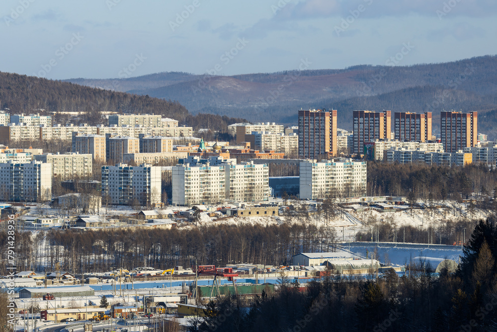 Obraz premium Tynda city, Amur region, Siberia, Russia. Winter city landscape. View of residential buildings. Mountains in the distance.