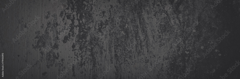 Fototapeta premium Texture of old concrete wall. Rough faded dark gray concrete surface with spots, cracks, noise and grain. Dark wide panoramic background for grunge style design. Shaded vintage texture with vignette.