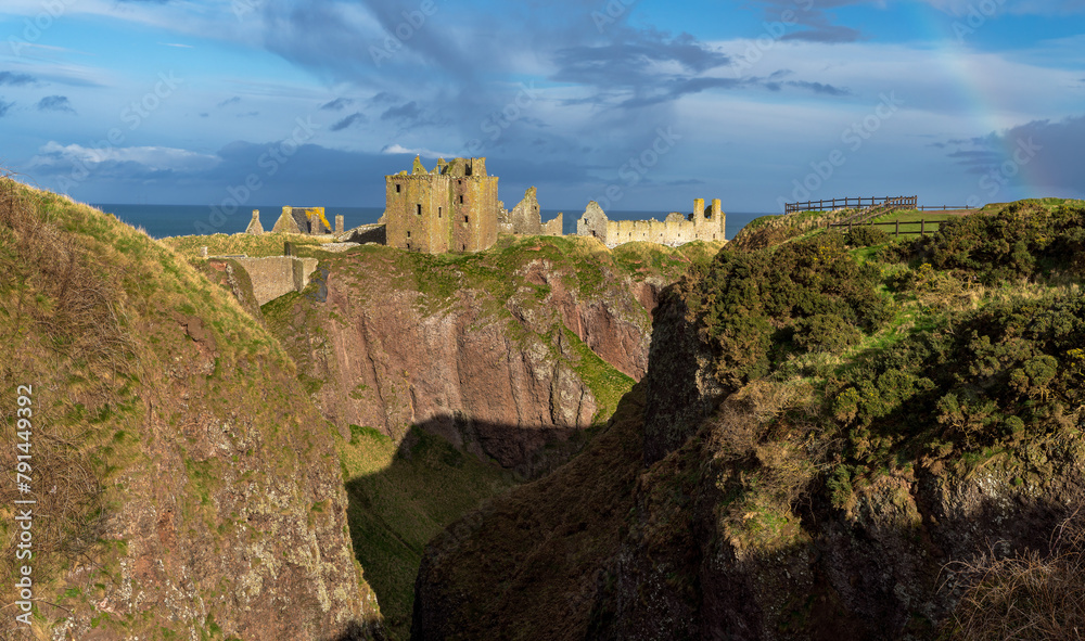 Fototapeta premium Mixed weather giving a slight rainbow at Dunnottar Castle near Stonehaven in Aberdeenshire, Scotland.