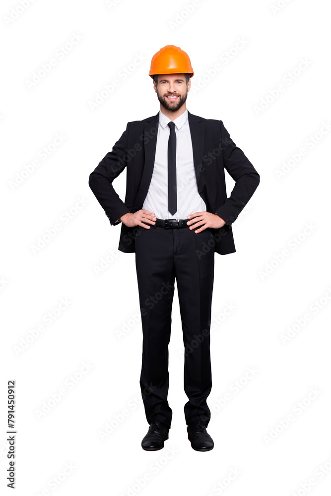 Full length size portrait of attractive cheerful joyful investor in orange hard hat and black tuxedo with tie, looking at camera, isolated on grey background, holding two arms on waist