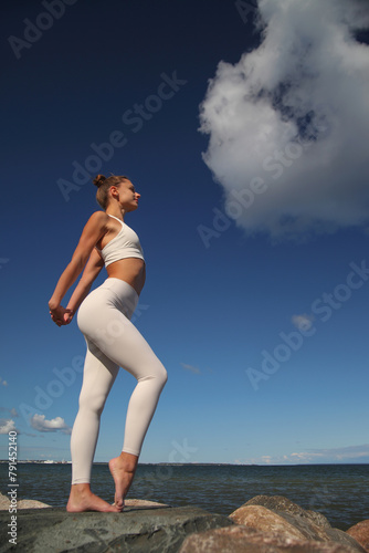 young athletic woman in white tracksuit by the sea