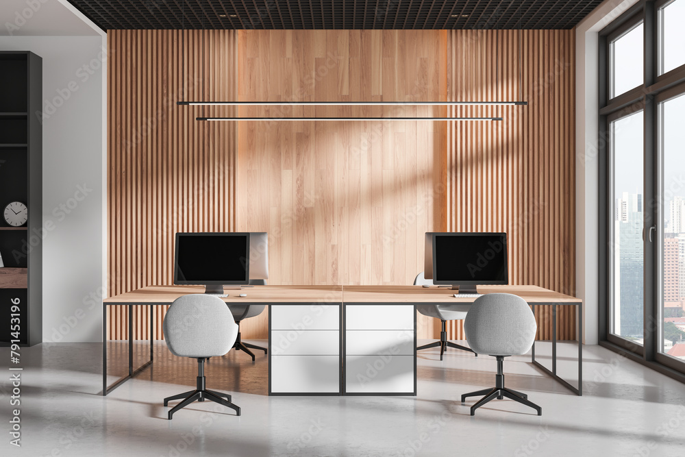 Obraz premium Modern workspace interior with pc monitors on tables, panoramic window