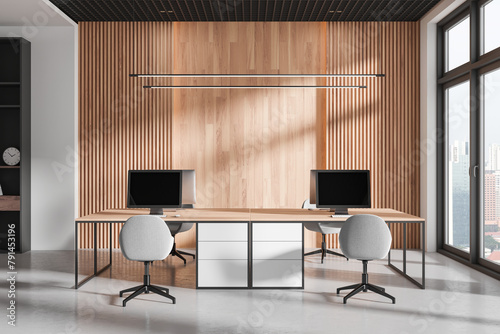 Modern workspace interior with pc monitors on tables, panoramic window © ImageFlow