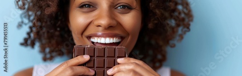 Excited African American woman holding a chocolate bar in front of her face photo
