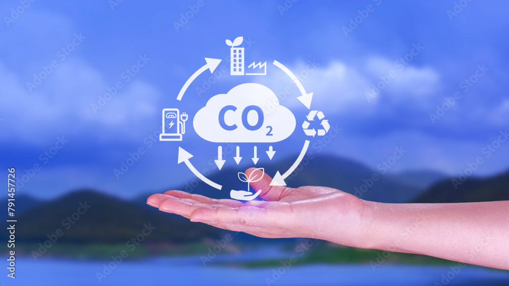 Hand holding CO2 reducing virtual icon for decrease carbon dioxide emission, carbon footprint and carbon credit to limit global warming from Bio climate change concept. - obrazy, fototapety, plakaty 