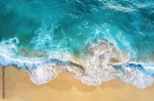 A top view of the beach with waves gently lapping at the golden sand